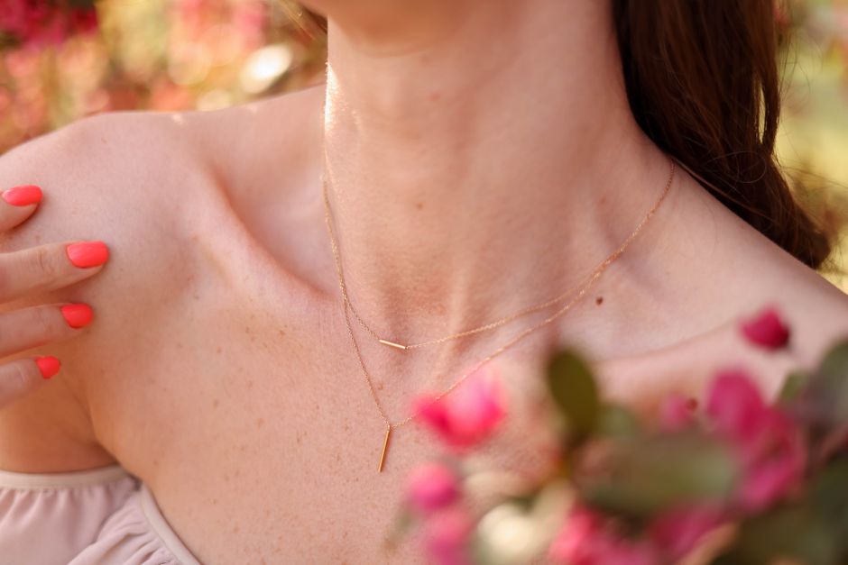 Close-up of a woman with a delicate necklace, showcasing beauty and elegance in a blooming