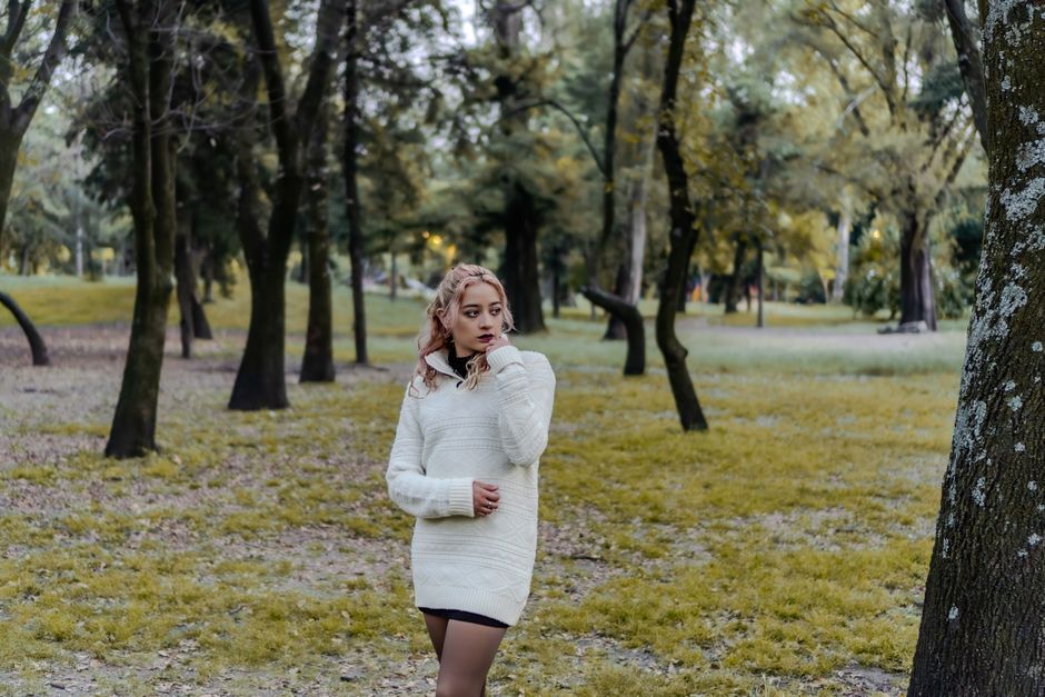 Woman strolling through a vibrant autumn forest in Mexico, embracing nature's beauty.